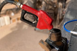 Un sortidor de gasoil omplint el dipòsit d'un tractor.