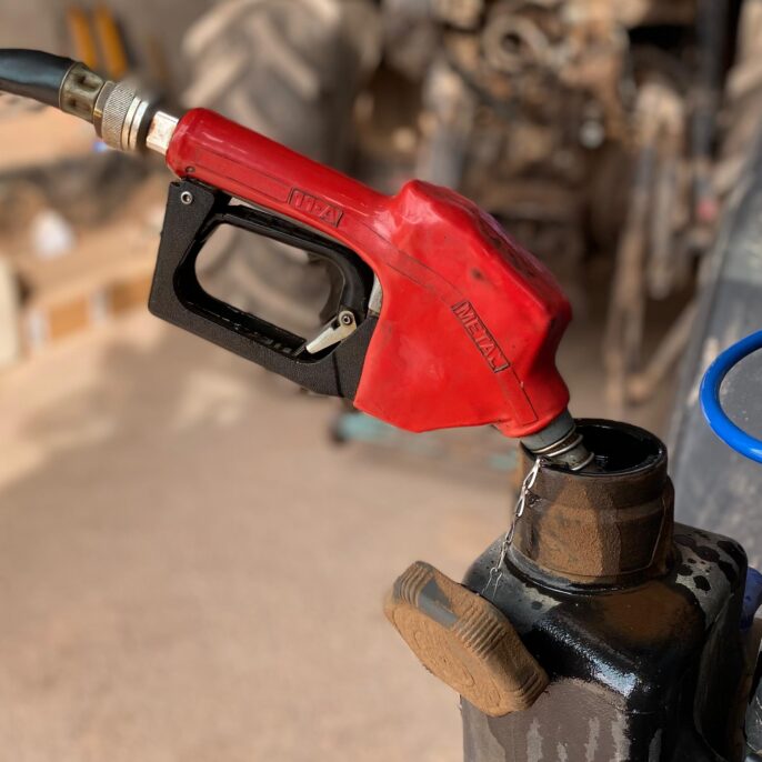 Un sortidor de gasoil omplint el dipòsit d'un tractor.